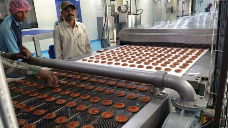 Stacks of packaged biscuits at a food manufacturing facility under food safety scrutiny
