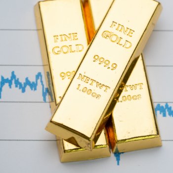 Gold bars and bullion stack on a rising price graph as investors weigh Fed rate hike odds
