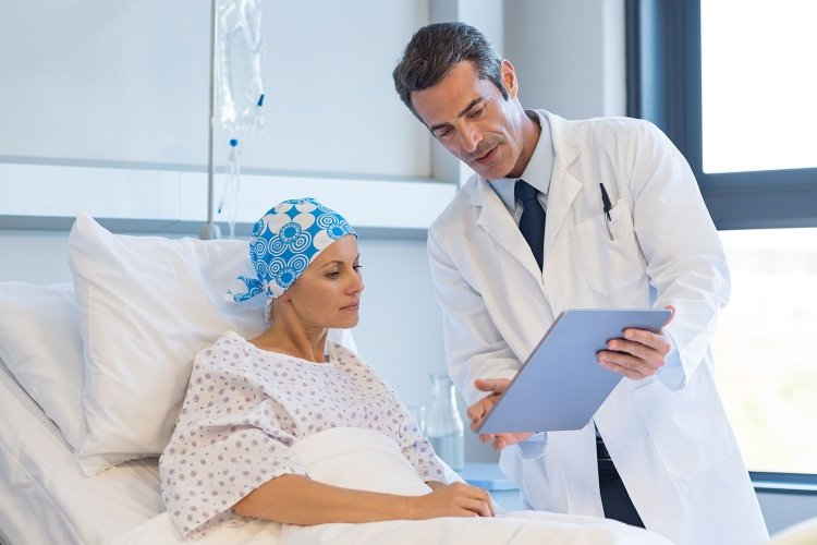 Cancer survival AI: oncologist consulting with a cancer patient in a hospital bed