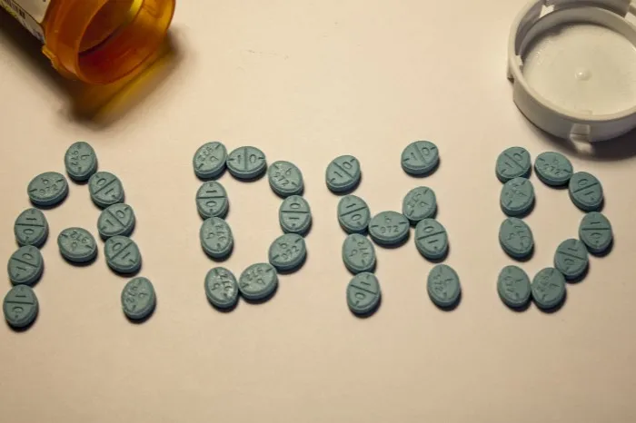 ADHD medication mortality: pills spelling out ADHD next to a prescription bottle