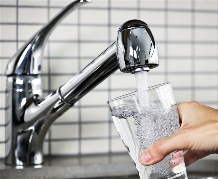 Glass of tap water being filled representing forever chemicals found in NJ tap water